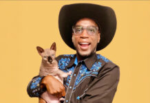 a man in a cowboy hat holding a cat
