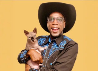 a man in a cowboy hat holding a cat