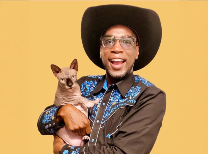 a man in a cowboy hat holding a cat