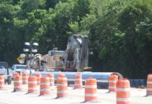 a large truck driving down a road surrounded by traffic cones
