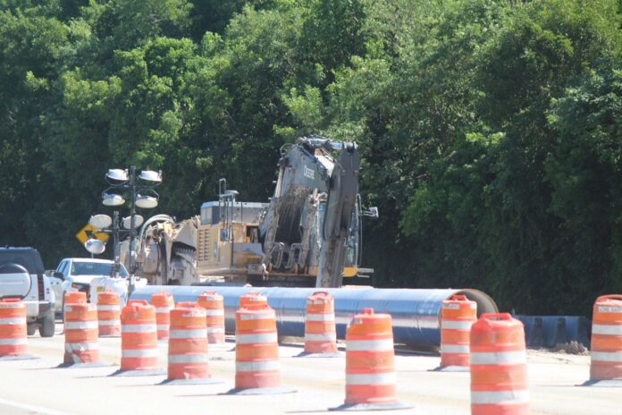a large truck driving down a road surrounded by traffic cones