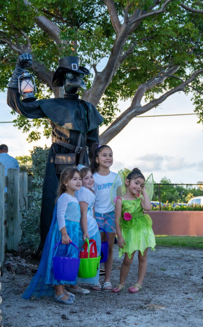 a group of children standing next to a statue