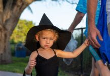 COSTUMED CUTENESS: MIDDLE KEYS KIDS CHASE CANDY AT TRICK OR TREAT AT SOMBRERO BEACH a little girl in a witches costume walking down the street
