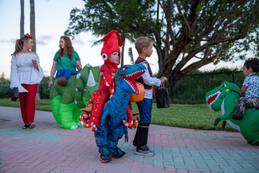 a group of children in costumes standing on a sidewalk