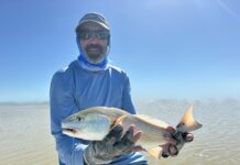 a man holding a fish on a boat