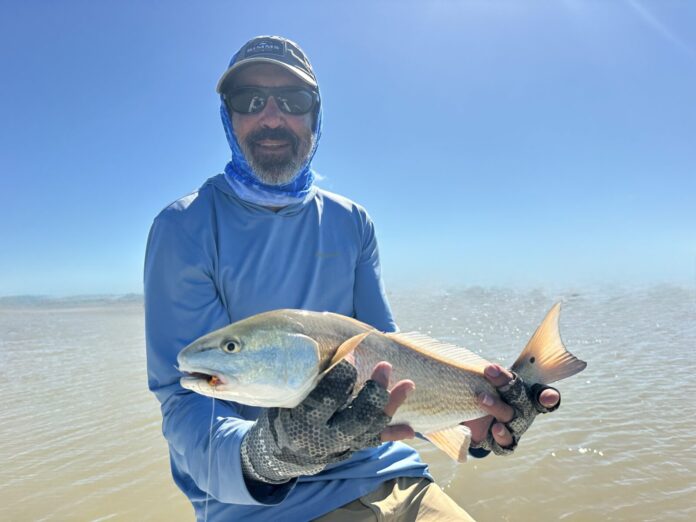 a man holding a fish on a boat