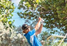 a man swinging a golf club on a golf course