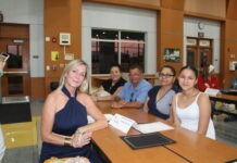 a group of people sitting around a wooden table