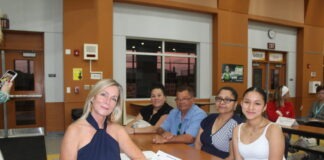 a group of people sitting around a wooden table