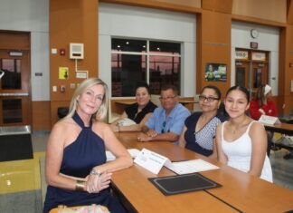 a group of people sitting around a wooden table