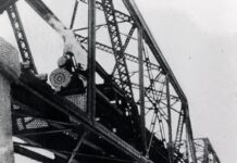 a black and white photo of a train bridge