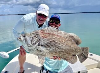 FLORIDA KEYS FISH REPORT: THE TALE OF THE LARGE TRIPLETAIL a man and a boy on a boat holding a fish