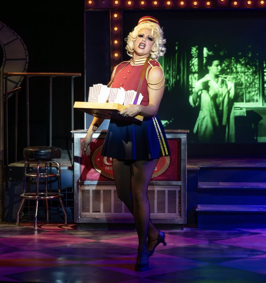 a woman holding a tray of food on a stage