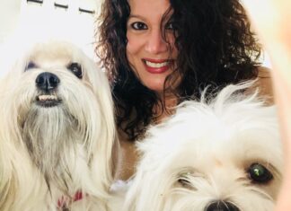 KEY LARGO’S WOMEN FOR PAWS HELPS BREAST CANCER PATIENTS CARE FOR THEIR ANIMALS a woman taking a picture of two white dogs