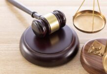 a judge's gaven and a scale on a wooden table