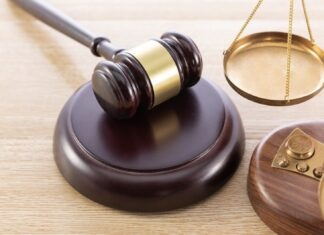 JUDGE MARK JONES TO RETIRE NEXT YEAR AFTER 30 YEARS ON THE BENCH a judge's gaven and a scale on a wooden table