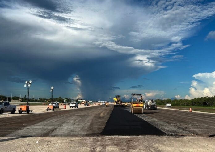 a road under a cloudy sky with construction equipment