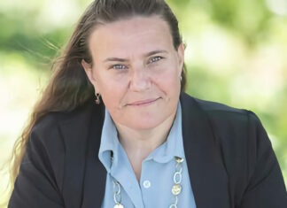 a woman in a blue shirt and black jacket