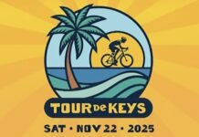 a man riding a bike down a street next to a palm tree