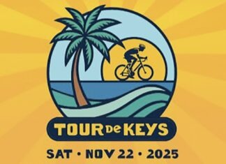 a man riding a bike down a street next to a palm tree