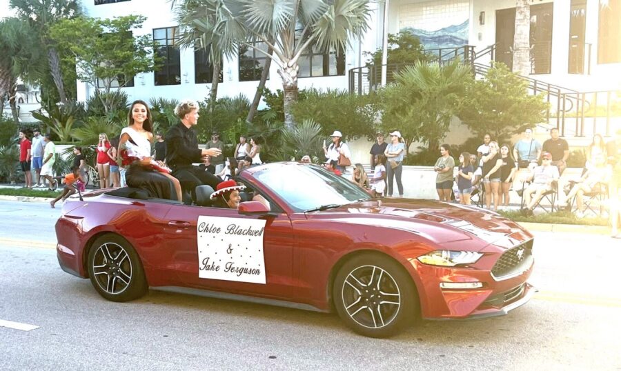 a red convertible car driving down a street