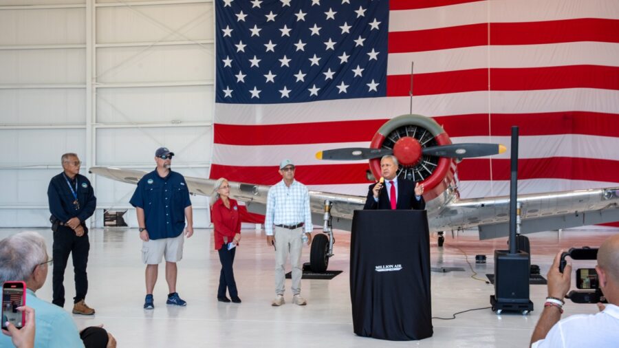 a man standing at a podium in front of an american flag