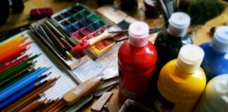 a wooden table topped with lots of different colored paints