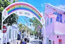 a painting of a city street with a rainbow arch