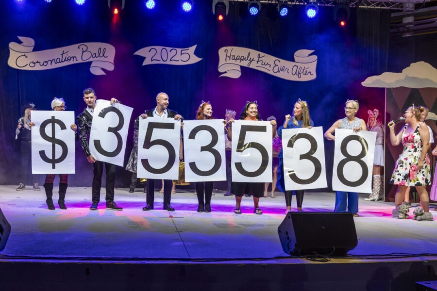 a group of people standing on a stage holding up signs