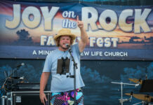 THIS WEEKEND: CELEBRATE FAITH, FAMILY & FELLOWSHIP AT JOY ON THE ROCK IN MARATHON a man standing on a stage with a microphone