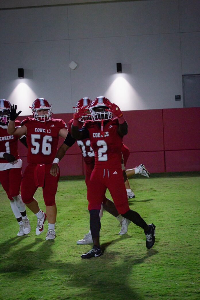 a group of football players standing on top of a field