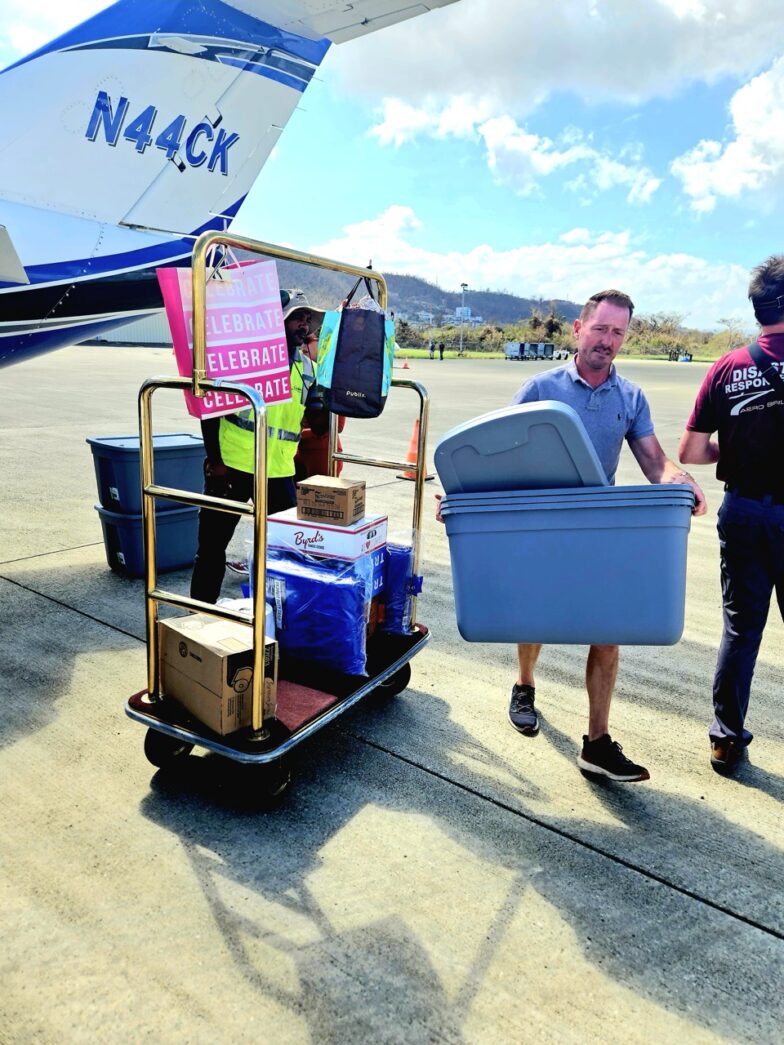 a group of people loading luggage onto an airplane