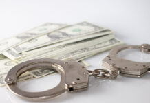 a pair of handcuffs sitting on top of a pile of money