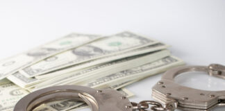 a pair of handcuffs sitting on top of a pile of money