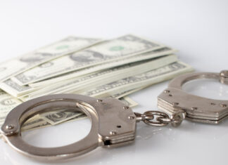 a pair of handcuffs sitting on top of a pile of money