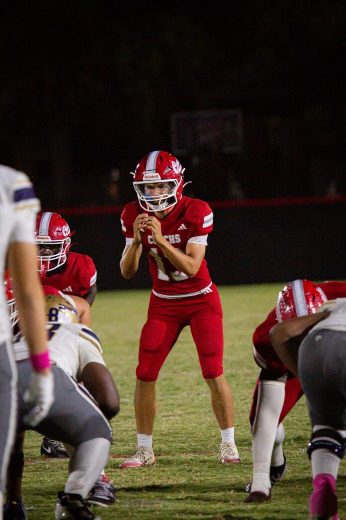 a football player holding a football on a field
