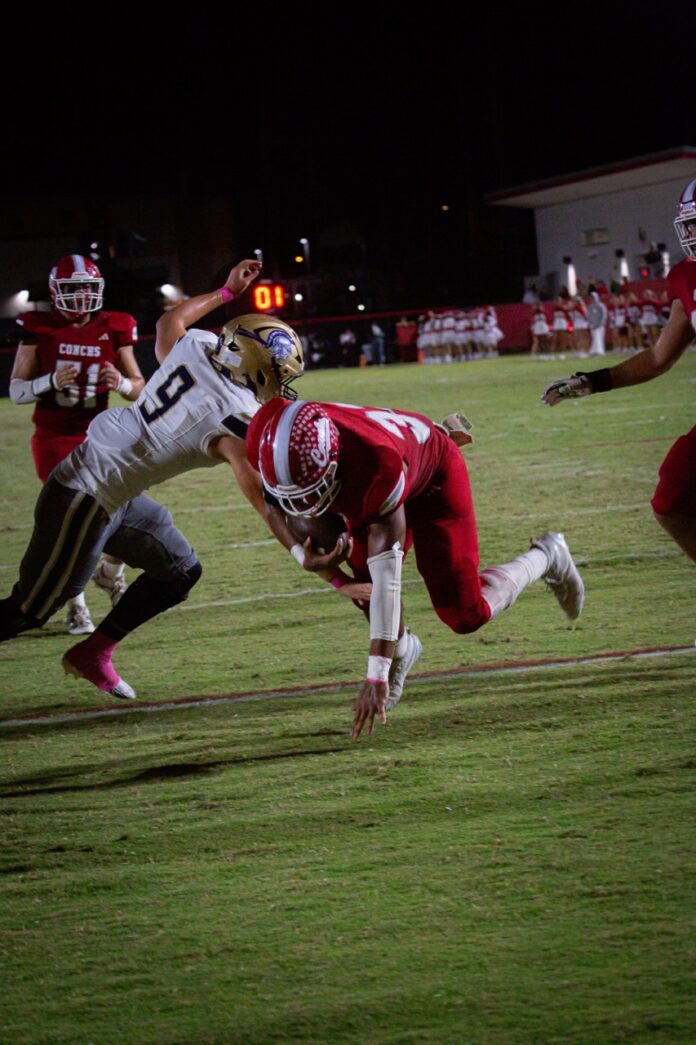 a football player dives for the ball
