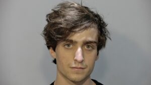 a man in a black shirt is looking at the camera