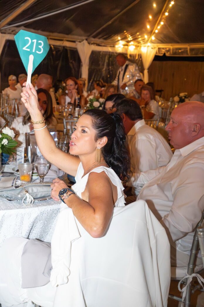 a bride and groom holding up a sign at their wedding reception