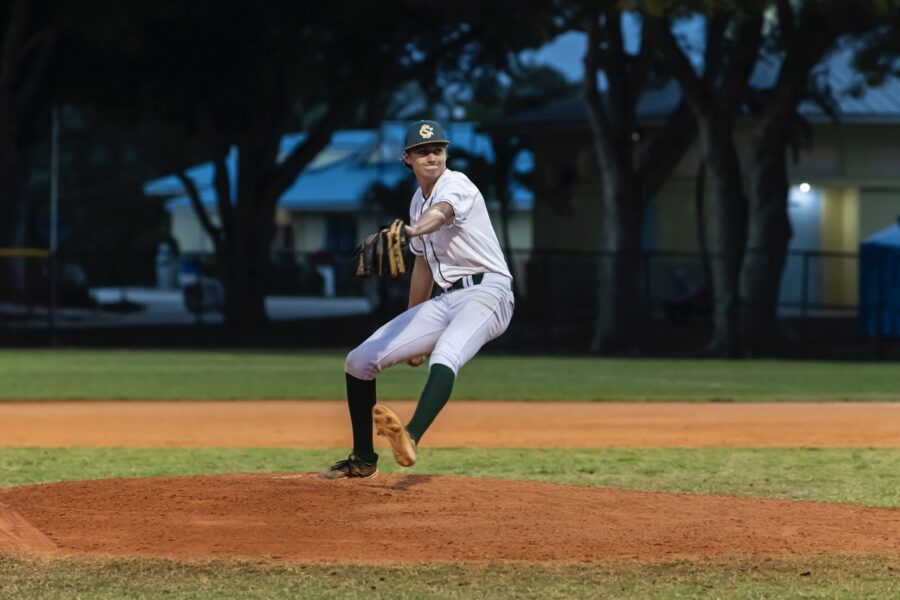 a baseball player pitching a ball on top of a field