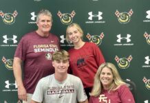 a group of people posing for a picture in front of a wall