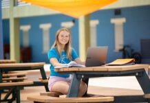 a woman sitting at a table with a laptop