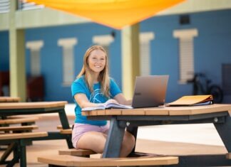 a woman sitting at a table with a laptop