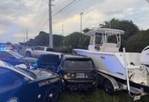 a police car and a boat on the side of the road