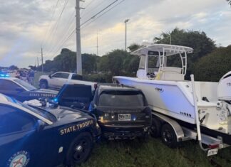 a police car and a boat on the side of the road