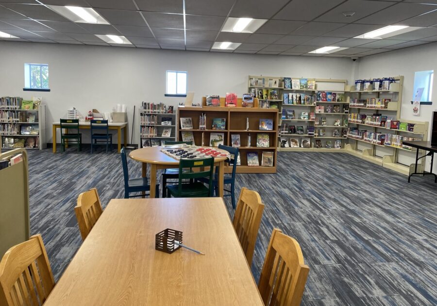a classroom with tables, chairs, and a television