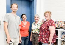 a group of people standing in front of a blue door