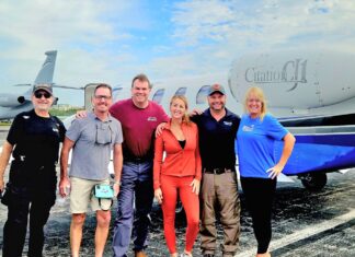 KEYS WEEKLY JOINS DISASTER RELIEF MISSION TO JAMAICA a group of people standing in front of an airplane