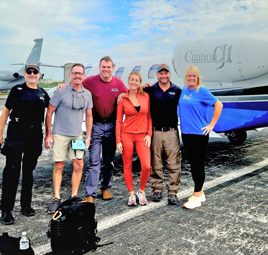 a group of people standing in front of an airplane