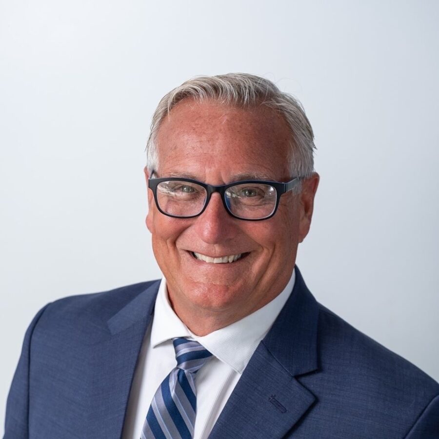 a man in a suit and tie smiling at the camera